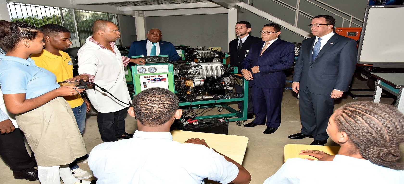  imagen Ministro de educaci&oacute;n Andres Navarro junto a director Rafael Ovalles y&nbsp; grupo de estudiantes de Infotep. Uno de los estudiantes realiza una demostraci&oacute;n flojando tuerca de un motor. 