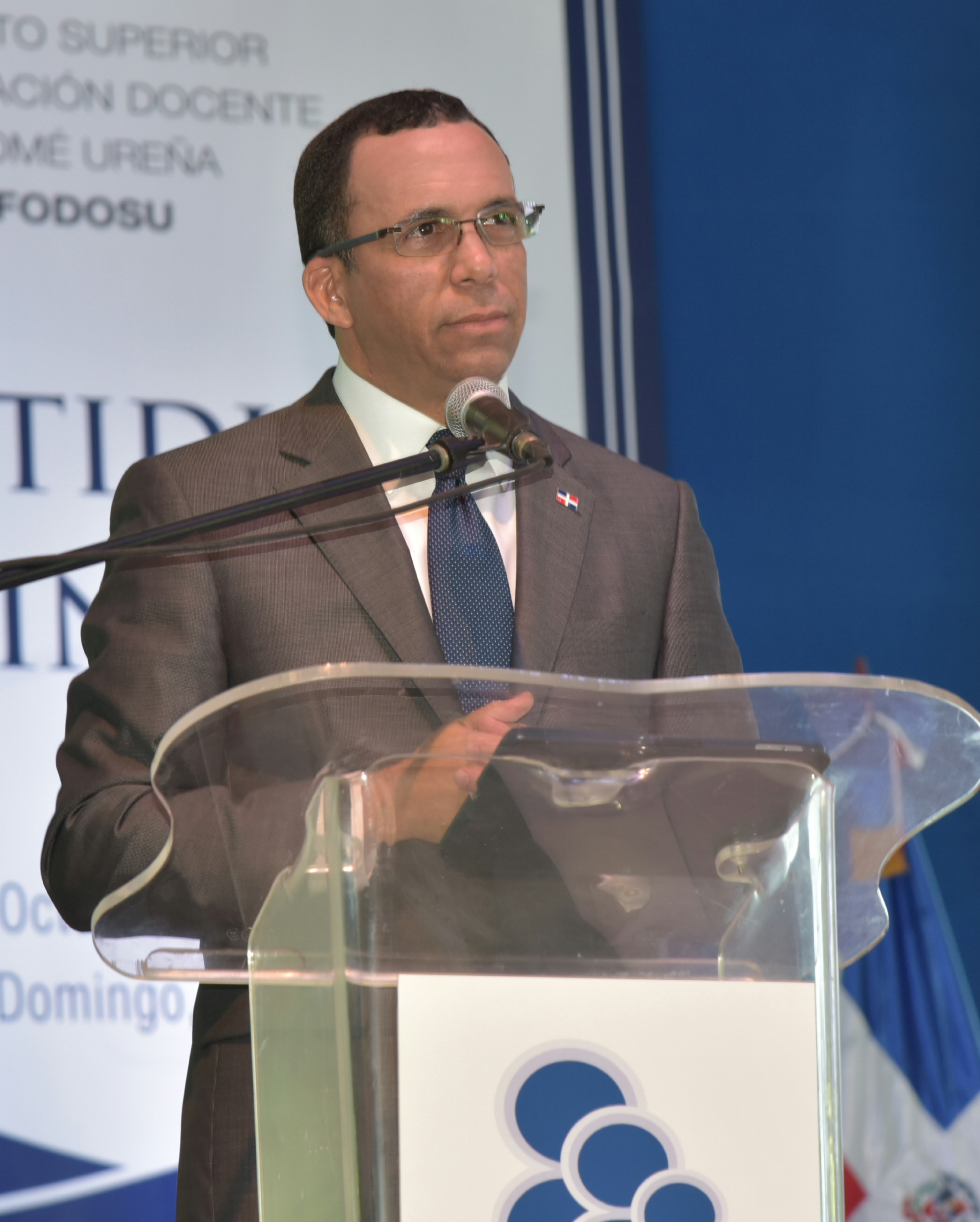  imagen Ministro Andr&eacute;s Navarro de pie en podium al lado de mesa de honor, dirigiendo discurso central en&nbsp;acto de graduaci&oacute;n de 459 nuevos profesionales de educaci&oacute;n de la investidura ordinaria del Instituto Superior de Formaci&oacute;n Docente Salom&eacute; Ure&ntilde;a (ISFODOSU) 