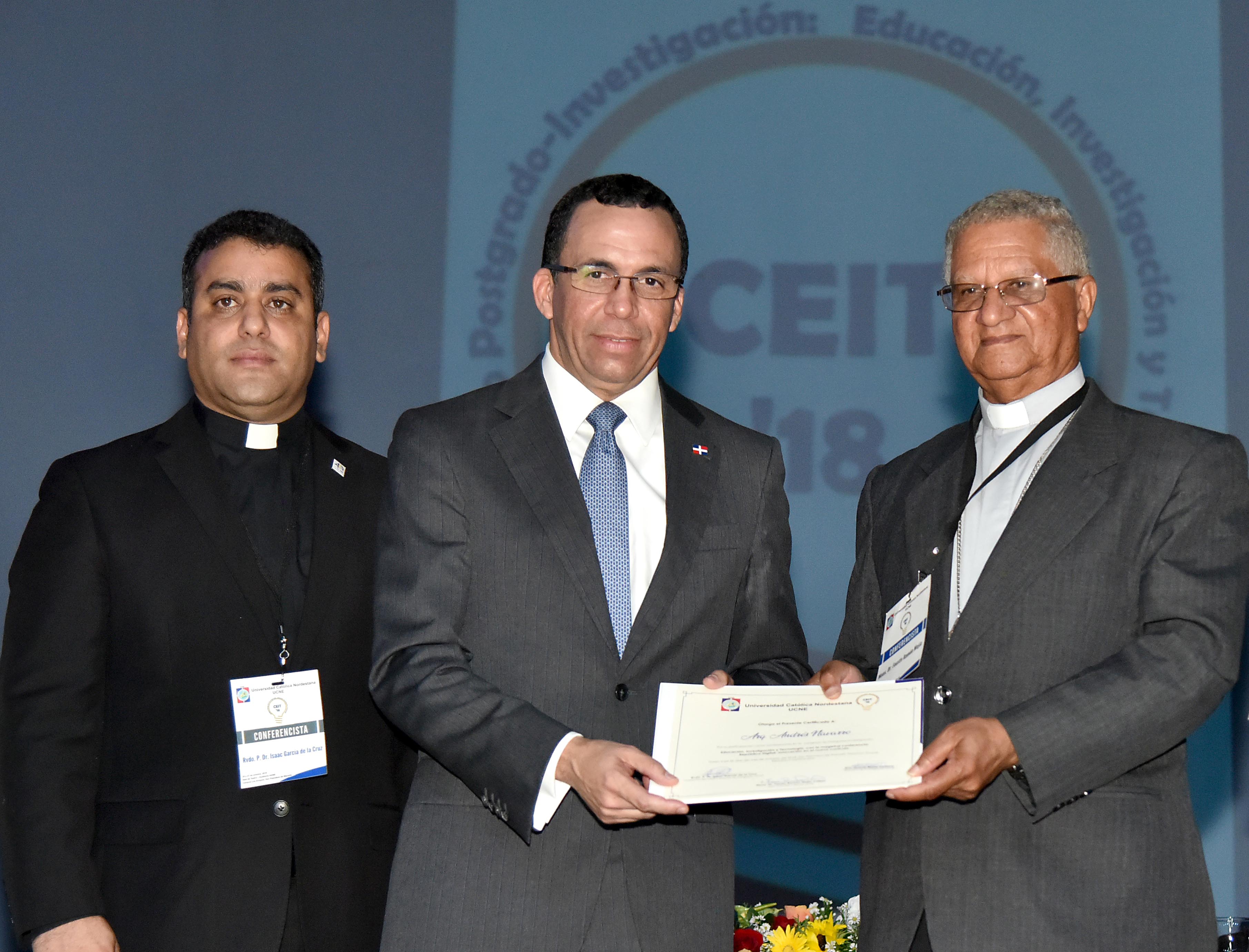  imagen Ministro Andr&eacute;s Navarro de pie en podium exponiendo discurso al lado de mesa principal en posgrado de la Universidad Cat&oacute;lica Nordestana 