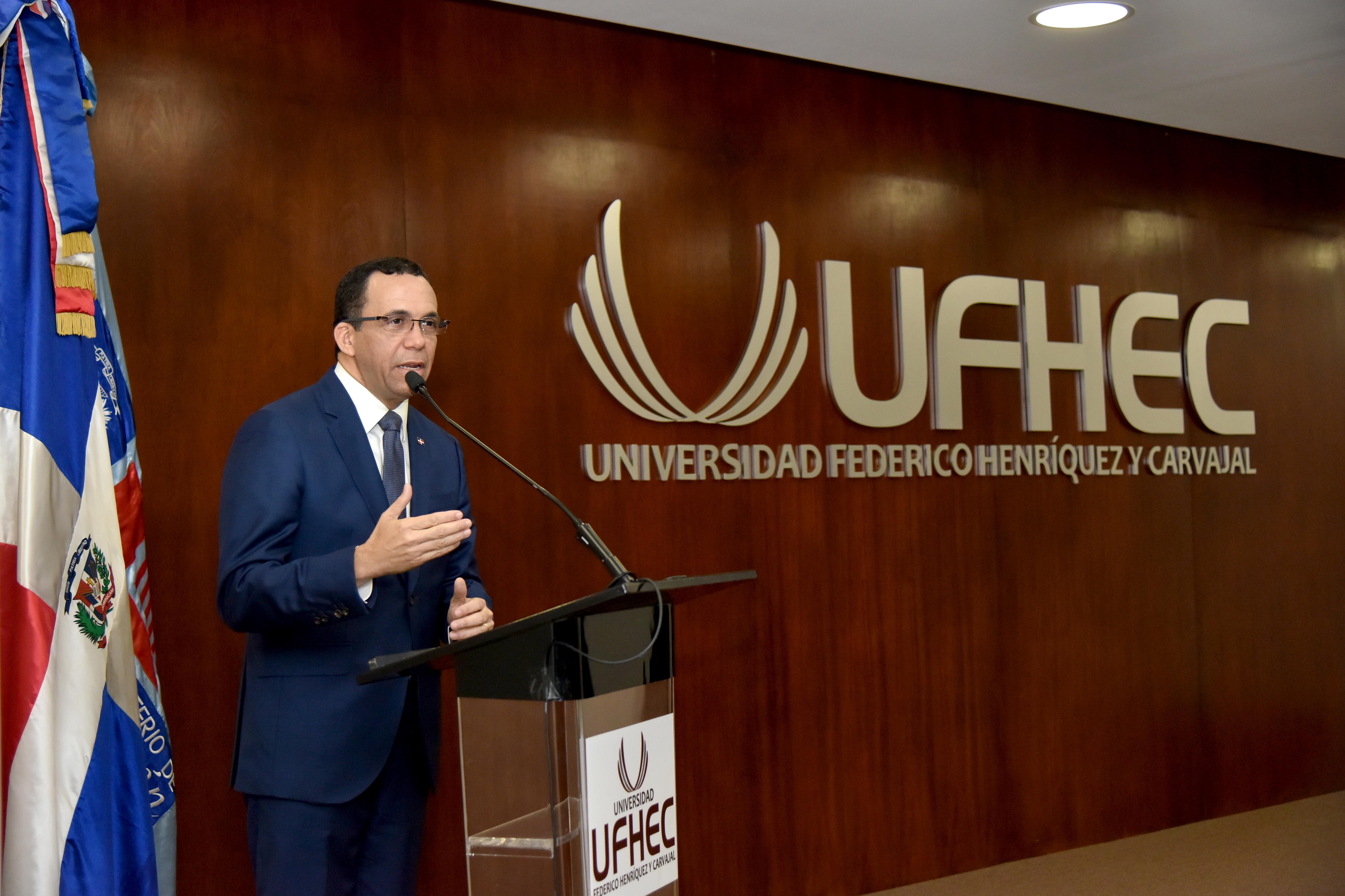  imagen Ministro Andr&eacute;s Navarro de pie en podium dirigiendo discurso a personas en auditorium de la universidad Federico Henr&iacute;quez y Carvajal&nbsp; 