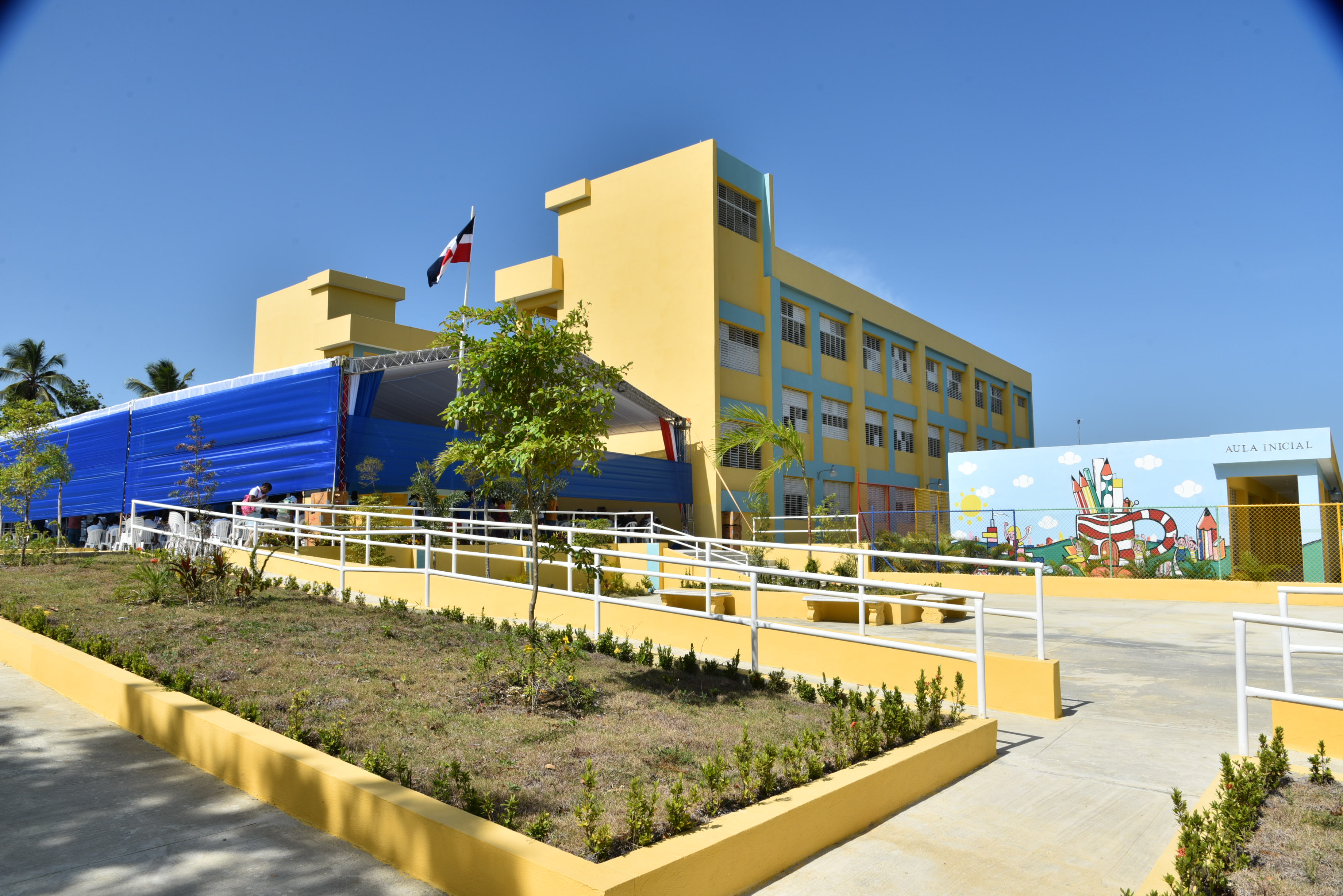  imagen Presidente Danilo Medina de pie cortando cinta acompa&ntilde;ada del Ministro Antonio Pe&ntilde;a Mirabal y dem&aacute;s autoridades educativas en entrega&nbsp;un moderno centro educativo que albergar&aacute; a otros 945 estudiantes en el municipio Santo Domingo Norte. 