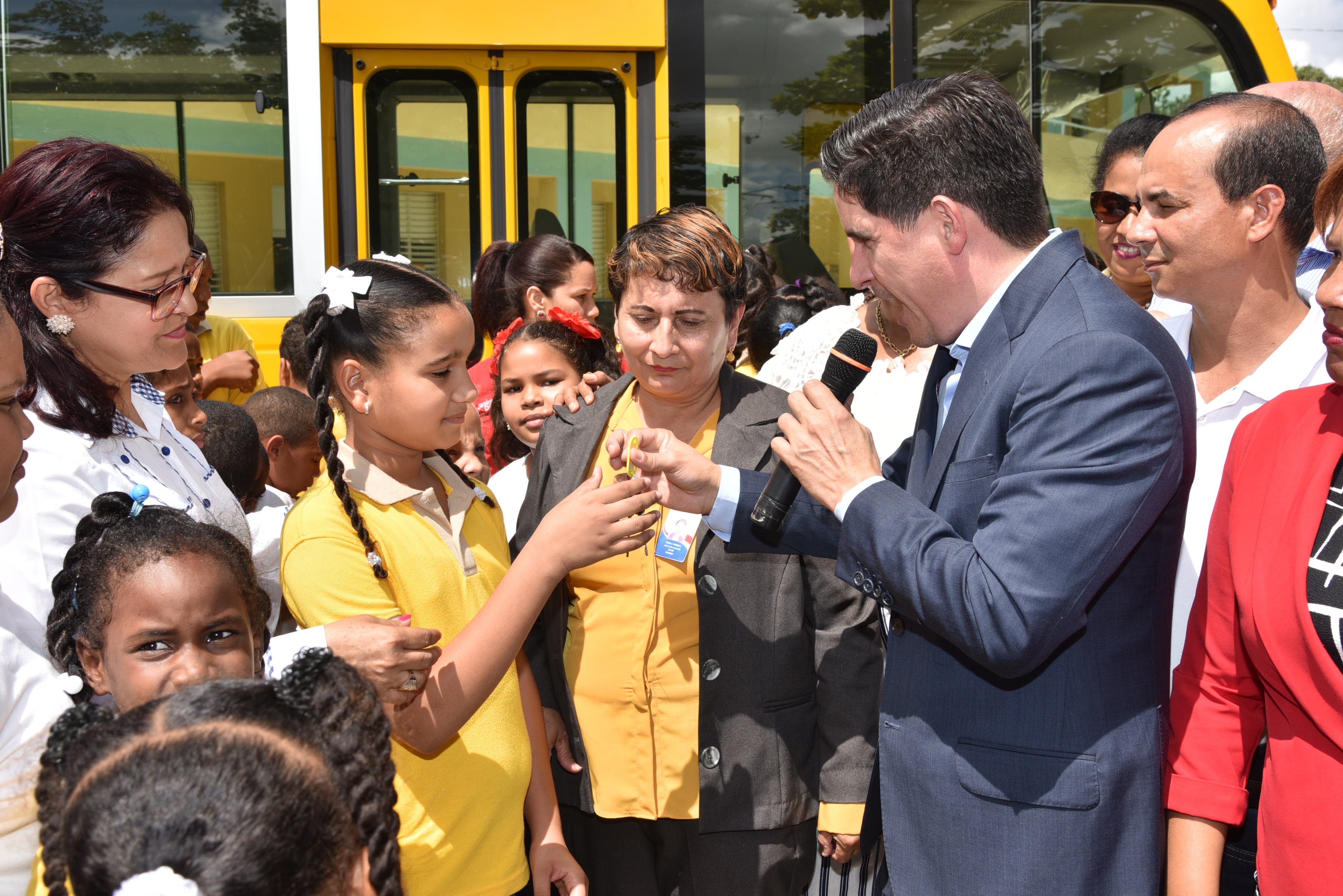  imagen Director Administrativo MINERD, Jorge Luis Moronta de pie entregando llave de nuevo autob&uacute;s escolar a representabtes de la comunidad educativa de Partido Dajab&oacute;n&nbsp; 