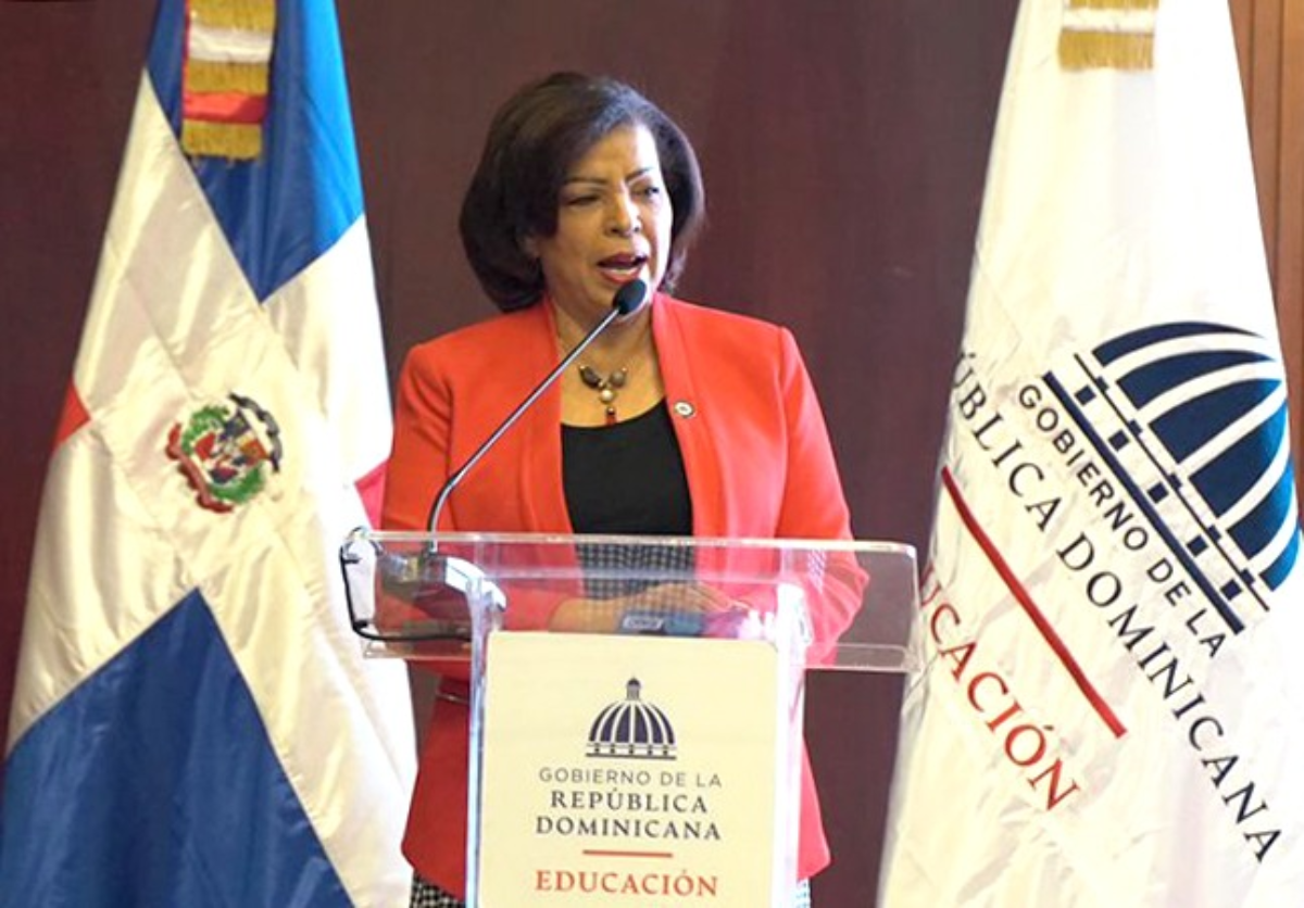  imagen Mike Major, especialista en est&aacute;ndares ling&uuml;&iacute;sticos, en el Aula Magna de la Universidad Aut&oacute;noma de Santo Domingo (UASD) de pie junto a otras autoridades educativas. 