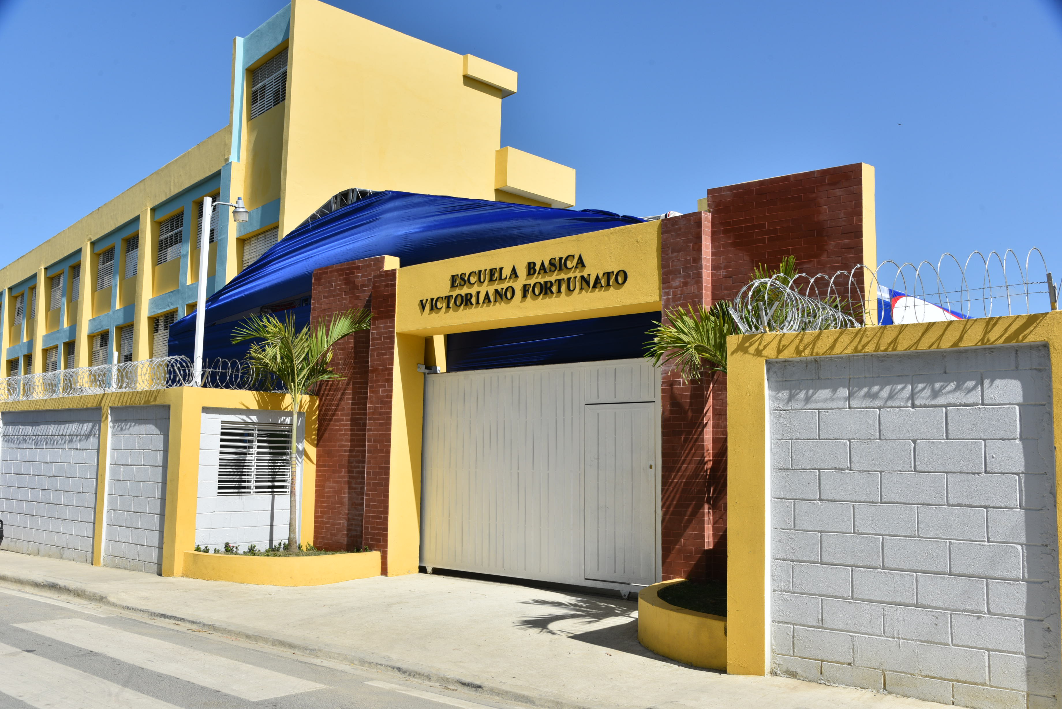  imagen Presidente Danilo Medina de pie cortando cinta acompa&ntilde;ada del Ministro Antonio Pe&ntilde;a Mirabal y dem&aacute;s autoridades educativas en entrega&nbsp;un moderno centro educativo que albergar&aacute; a otros 945 estudiantes en el municipio Santo Domingo Norte. 