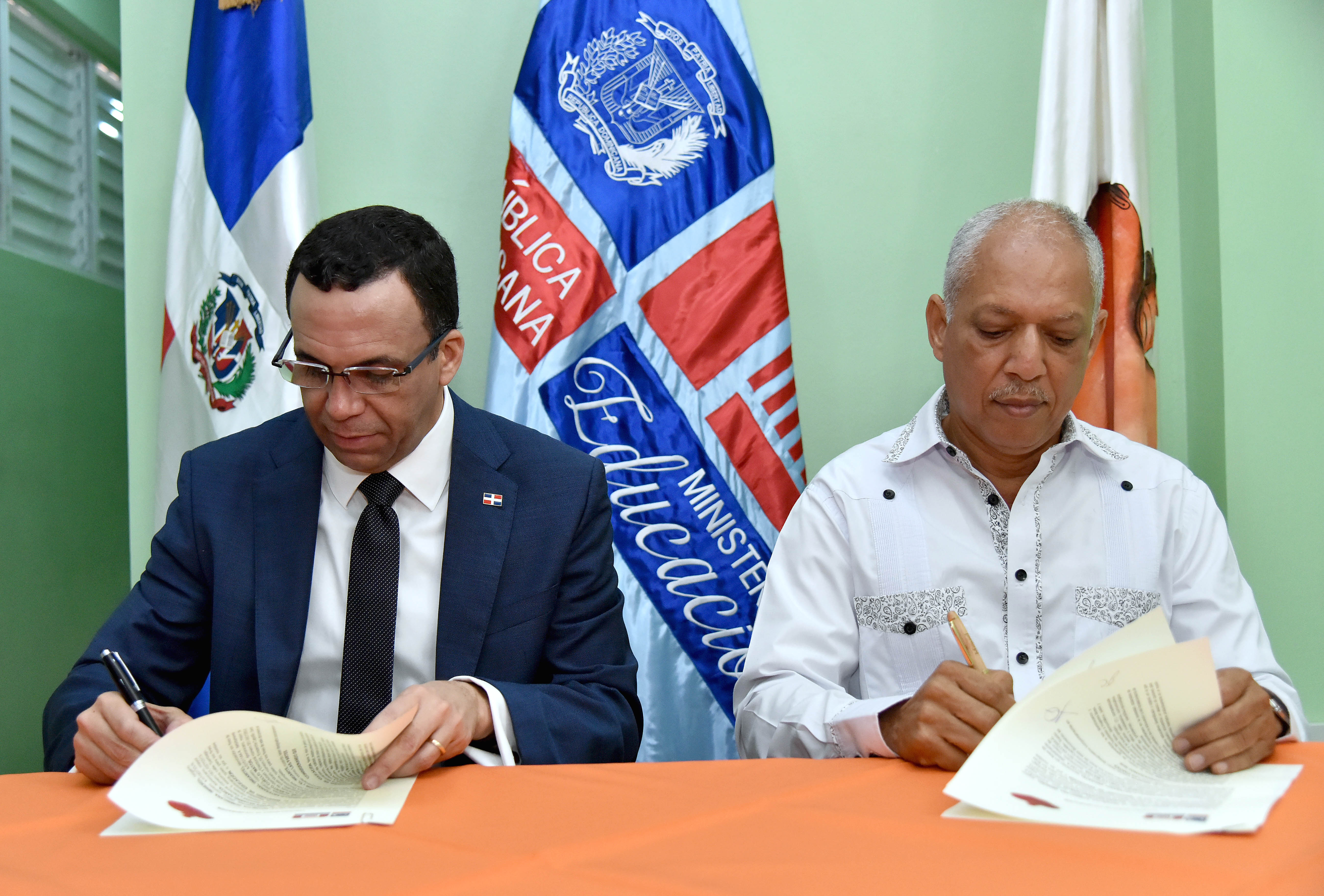  imagen Ministro Andr&eacute;s Navarro y director de INDARTE&nbsp; sentados firmando acuerdo de cooperaci&oacute;n para promover el arte en las escuelas de Capotillo&nbsp; 