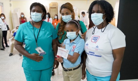  imagen Personal de vacunaci&oacute;n junto a estudiante, mostrando tarjeta de vacunaci&oacute;n a la c&aacute;mara. 