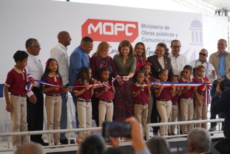  imagen Vicepresidenta de la Rep&uacute;blica corta cinta sostenida por grupo de infantes durante el acto. A su lado autoridades de la mesa de honor, entre ellos el Sr. Oscar Amarg&oacute;s. 