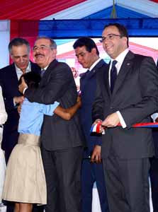  imagen Presidente Danilo Medina sonriente abraza una estudiante. A su lado el Ministro Andr&eacute;s Navarro, entre otras personalidades. 