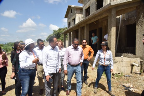  imagen Ministro de educaci&oacute;n conversa con sus acompa&ntilde;antes mientras recorre una de las contrucciones. 