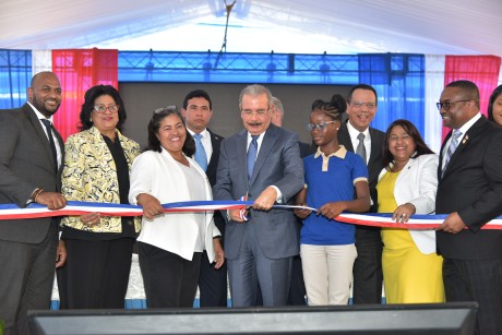  imagen Presidente Danilo Medina de pie cortando cinta acompa&ntilde;ada del Ministro Antonio Pe&ntilde;a Mirabal y dem&aacute;s autoridades educativas en entrega&nbsp;un moderno centro educativo que albergar&aacute; a otros 945 estudiantes en el municipio Santo Domingo Norte. 