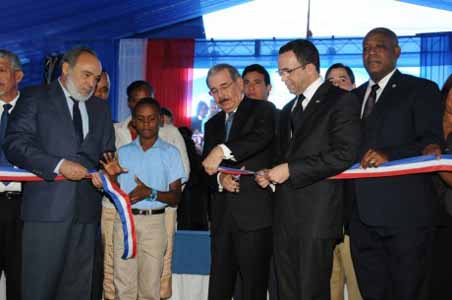  imagen Presidente Danilo Medina mientras corta cinta en acto de inauguraci&oacute;n; a su lado izquierdo el Ministro Andr&eacute;s Navarro y otras personalidades. 