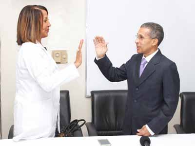  imagen Momento de juramentaci&oacute;n de doctora Adames Chapman por doctor Enriquillo Matos. Ambos con mano derecha alzada a nivel de los hombros. 